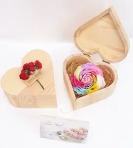 Detail van houten geschenkdoos in hartvorm met kleurrijke zeeproos en handgemaakt label.