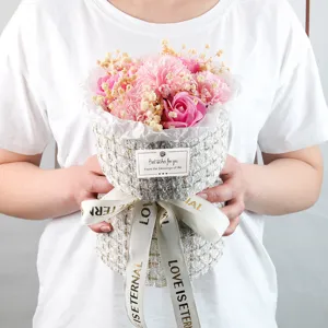 Bouquet di fiori di sapone rosa tenuto in mano con confezione in tweed e nastro Love Is Eternal.