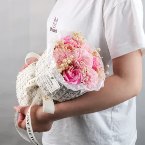 Vista dettagliata di un bouquet di fiori di sapone rosa in elegante confezione regalo in tweed