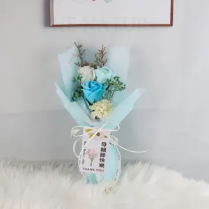 Gedetailleerd beeld van een blauw zeepbloemenboeket met rozen en een wenskaartje