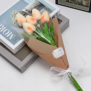 Gros plan d'un bouquet de tulipes artificielles pêche avec nœud en dentelle et carte