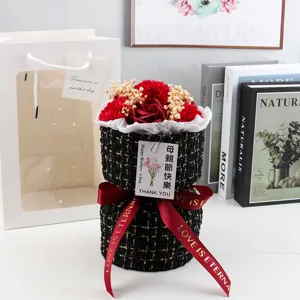 Dettaglio di garofani e rose di sapone in una scatola regalo in tweed per la festa della mamma