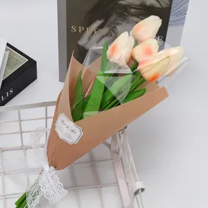 Gros plan d'un bouquet de tulipes artificielles en papier kraft avec un nœud en dentelle.