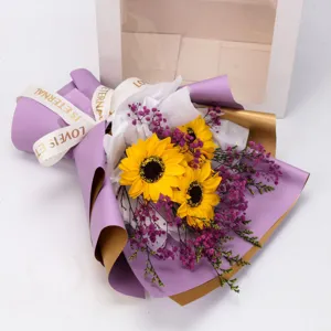 Künstlicher Sonnenblumen Blumenstrauß mit lila und goldener Verpackung als Geschenk