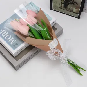 Gros plan d'un bouquet de tulipes artificielles roses avec ruban en dentelle