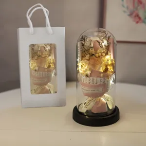 Detailed view of the LED glass dome preserved flower gift with warm lights and bouquet.