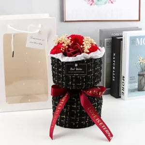 Vista dettagliata di un elegante bouquet di fiori di sapone in tweed con nastro rosso