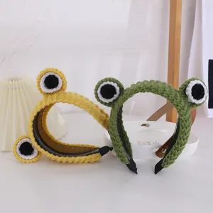Cute knitted frog headband detail shot, fuzzy wool hair hoop with big eyes for winter style.