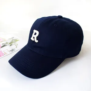 Detail of navy blue baseball cap with white embroidered R letter logo