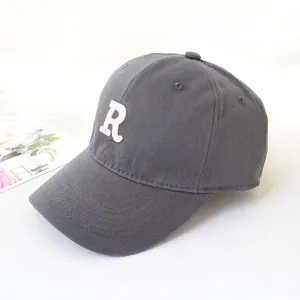 Detailed side view of a grey baseball cap featuring a white embroidered letter R
