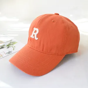 Orange baseball cap with white embroidered R letter, stylish minimalist sun hat for men and women.