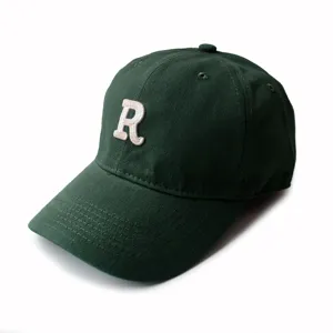 Detail of dark green baseball cap featuring high-quality white 3D R letter embroidery.