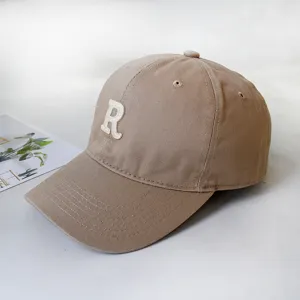 Macro view of khaki cotton baseball cap with a white embroidered letter R on front