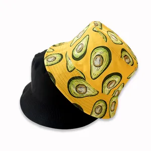 Close-up detail of reversible avocado bucket hat with yellow print and solid black side.