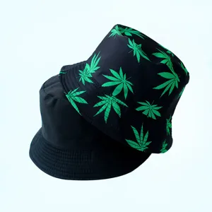 Vue détaillée du chapeau réversible avec un côté noir uni et un motif de feuilles vertes.