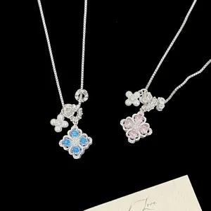 Detail of silver clover necklaces with vibrant zircon stones and delicate pearl charms