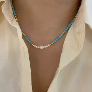 Dettaglio di un'elegante collana con perle d'acqua dolce e perline turchesi sul collo