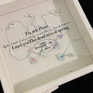 Detailed macro view of delicate silver star pendants with pink, purple, and blue zircons.