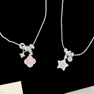 Close-up of silver-tone necklaces with pink clover and blue star zircon pendants