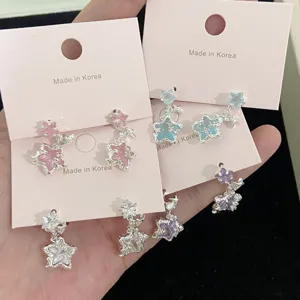 Close-up view of micro-pave cubic zirconia star drop earrings in various pastel colors.