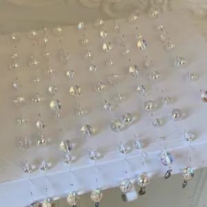 Detailed macro view of clear crystal bead necklace with shimmering finish on white base.