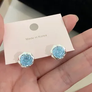 Primer plano de pendientes de circonita azul con efecto brillante de corte rosa