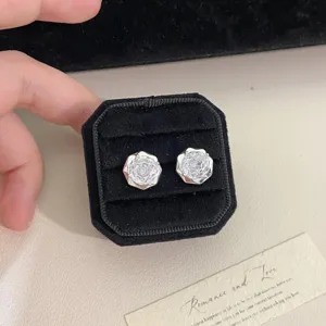 Primer plano de pendientes de circonita con corte de rosa en un estuche de terciopelo negro.