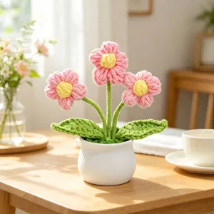 Detailed macro view of finished handmade pink crochet flowers in a minimalist white ceramic pot