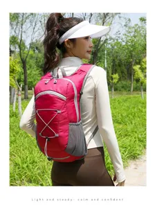 Woman carrying a lightweight pink outdoor cycling backpack in a lush green park setting