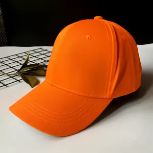 Detail of a vibrant orange baseball cap with a classic curved brim design