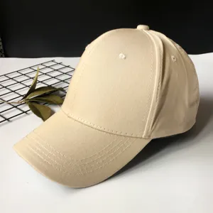 Close-up detail of a minimalist beige baseball cap showcasing the curved brim and texture