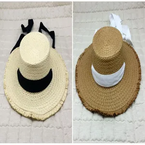 Two styles of straw sun hats with frayed edges and decorative ribbons for summer beach