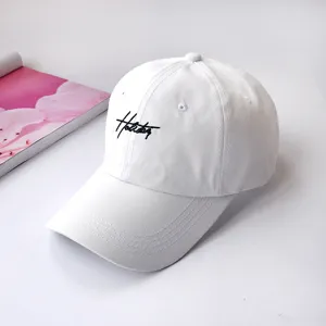 Close-up detail of a white soft-top baseball cap with black embroidered script logo lettering.