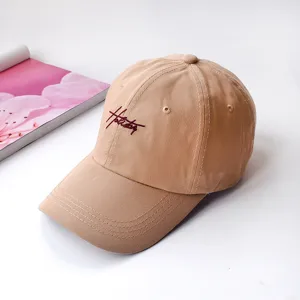 Detailed close-up of khaki baseball cap featuring delicate front embroidery and soft top.