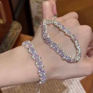 Elegante pulsera de perlas de doble capa estilo francés con circonitas moradas en mano