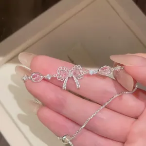 Dettaglio bracciale fiocco argento con pietre rosa e chiusura regolabile
