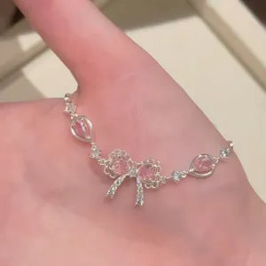 Squisito bracciale a fiocco argentato con scintillanti cristalli rosa a forma di cuore