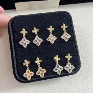 Detailed macro of four pairs of colorful crystal flower earrings on velvet tray