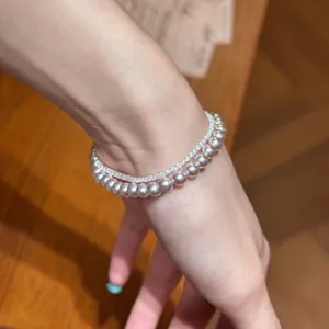 Detalle de una elegante pulsera francesa de doble capa con perlas y circonitas en la muñeca
