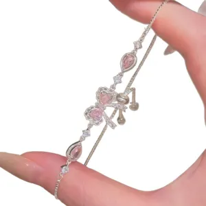 Elegante bracciale in argento regolabile con pietre a cuore rosa e fiocco mostrato sulla mano