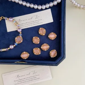 Detailed view of elegant purple pearl bracelet with gold and pink oval charms