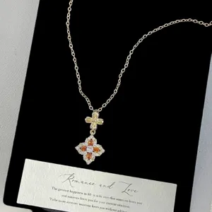 Close-up of vintage French style gold necklace with colorful four-leaf flower pendant