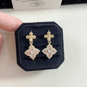Detailed close-up view of vintage floral gold earrings with pink gemstones in a box