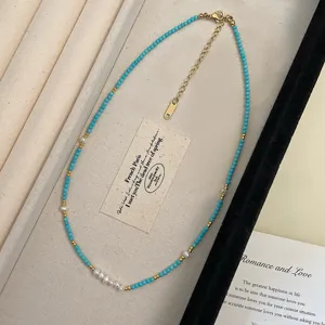Close-up of elegant turquoise stone and freshwater pearl beaded necklace with gold beads