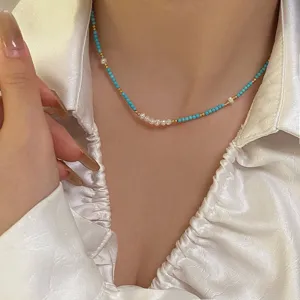 Detail view of a handmade necklace with natural freshwater pearls and turquoise stone beads.