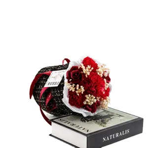 Elegante bouquet di fiori di sapone in borsa a secchiello in tweed con rose rosse e garofani