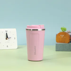 Eleganter rosa Edelstahl-Kaffeebecher auf einem minimalistischen Schreibtisch mit Requisiten