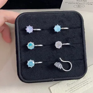 Close-up of sparkling colorful rose cut crystal ear cuffs in a black velvet display tray