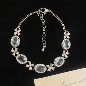 Élégant bracelet finition argentée avec cristaux ovales bleus et accents de trèfle étincelants