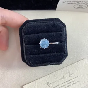 Detail view of a light blue rose cut crystal ring inside a black velvet gift box